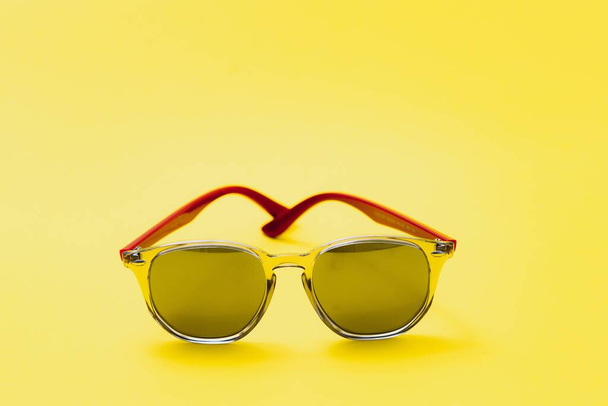 Стильні сонцезахисні окуляри на жовтому тлі Високоякісні фото сонцезахисні окуляри
. - Фото, зображення