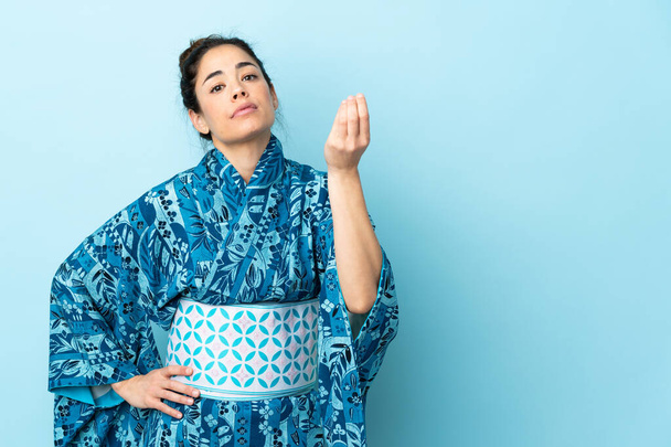 Woman wearing kimono over isolated background making Italian gesture - Foto, Imagem