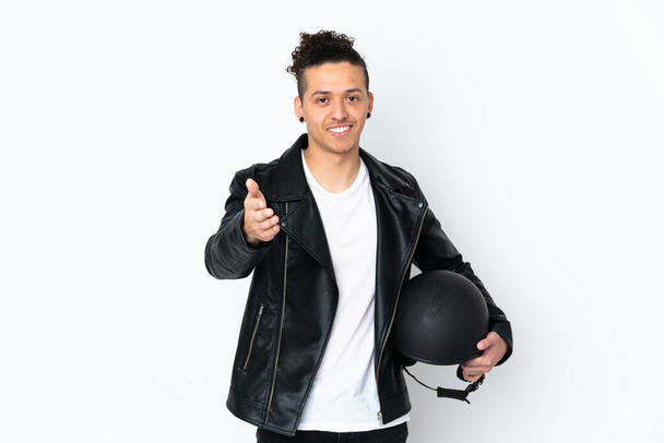Caucasian man with a motorcycle helmet over isolated white background handshaking after good deal - Fotó, kép
