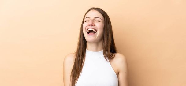 Young caucasian woman isolated on beige background laughing - Fotoğraf, Görsel