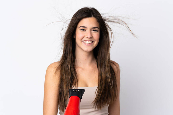 Teenager Brazilian girl with hairdryer over isolated white background - Foto, afbeelding
