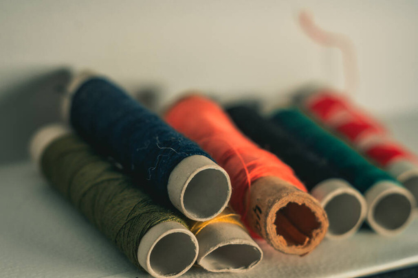 A high angle shot of colorful thread stocks half used and half new - Фото, изображение