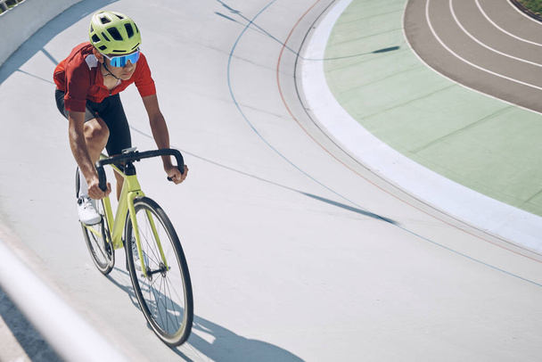 Confident man in sports clothing cycling on track outdoors - Foto, imagen