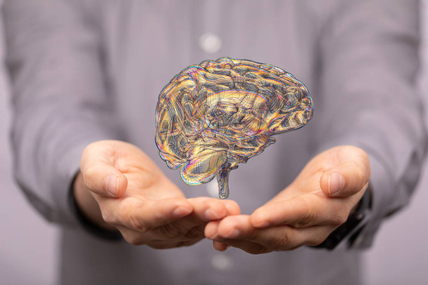A closeup of a 3d rendered brain in a man's hand - Foto, Imagen