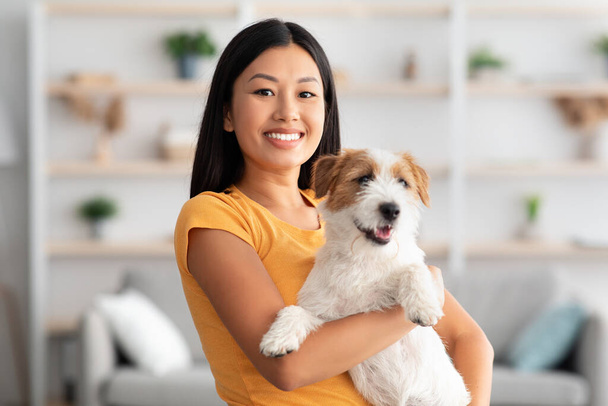 glimlachen aziatische vrouw poseren met haar mooie jack russel puppy - Foto, afbeelding