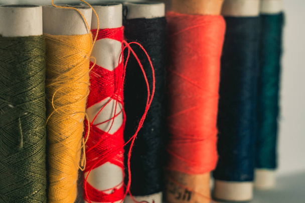 A selective focus shot of colorful thread on round stocks piled in row - Foto, Imagem