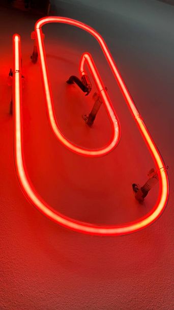 Forma de clip de oficina rojo luz de neón instalada en la pared blanca - Foto, Imagen
