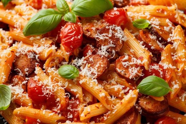 Worstjes pasta met tomatensaus, parmezaanse kaas en basilicum - Foto, afbeelding