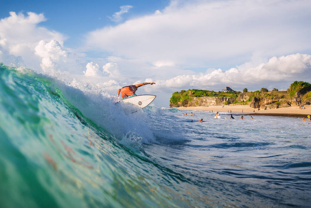 20 августа 2021 года. Бали, Индонезия. Серфер на доске для серфинга на синей волне. Серфинг в тропическом океане - Фото, изображение