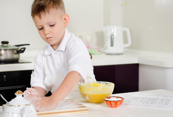 Bonito menino aprendendo a fazer bolos
 - Foto, Imagem