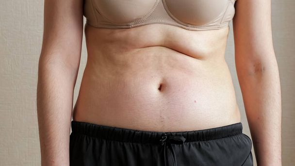 Unrecognizable woman touching belly fat - Фото, зображення