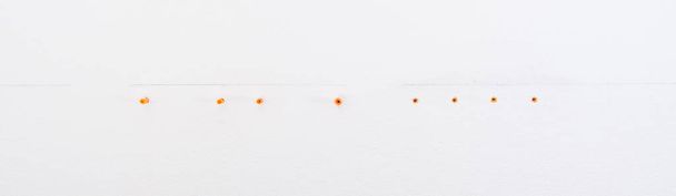 a row of orange plugs, for mounting on a concrete wall - Zdjęcie, obraz