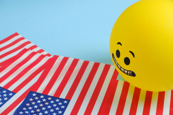 Yellow emoji balloons with American flags on a blue background. - Photo, Image