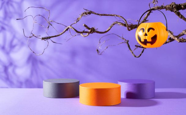 Halloween party concept. Podiums or pedestals for products display and pumpkin buckets for candies over purple background. Halloween holiday decorations. - Foto, Imagem