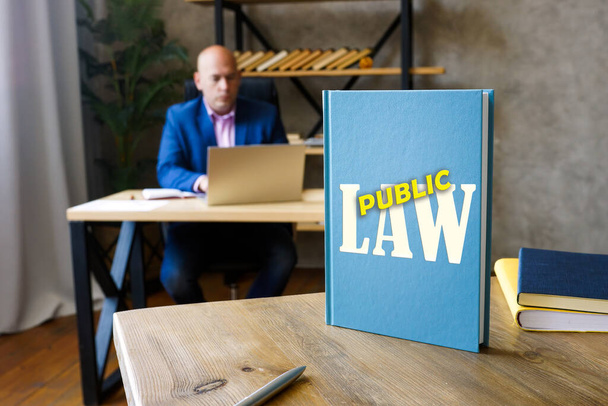  PUBLIC LAW book in the hands of a attorney. Public law comprises constitutional law, administrative law, tax law and criminal law, as well as all procedural la - Foto, Imagen