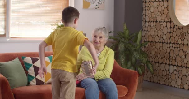 Маленький хлопчик дарує подарунок бабусі вдома
 - Кадри, відео