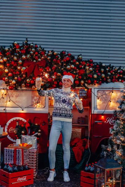 Young boy as a santa claus, celebrating new year with sparkles in hands - Фото, зображення
