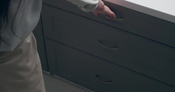 Nainen laittaa lusikat keittiön laatikkoon - Materiaali, video