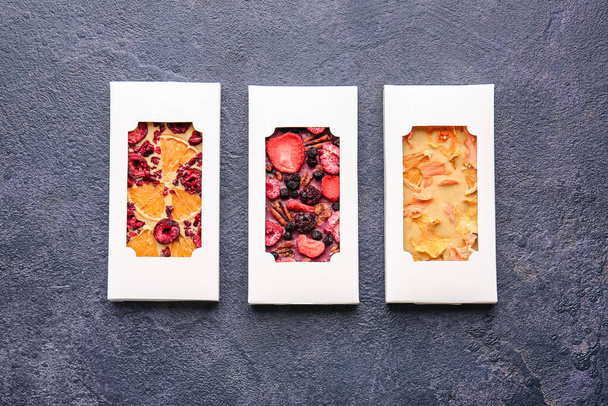 Handmade chocolate bars with fruits and berries on dark background - Foto, imagen