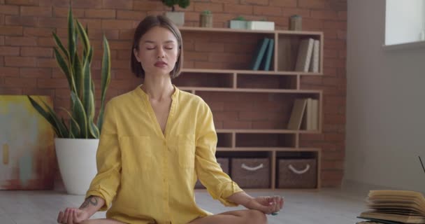 Krásná mladá žena medituje doma - Záběry, video