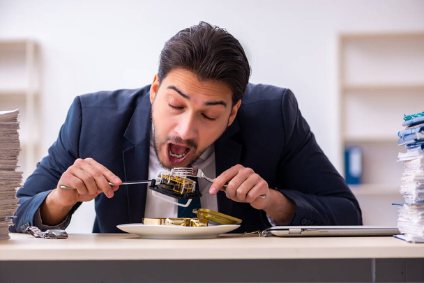 Young businessman employee eating alarm-clock - Фото, зображення