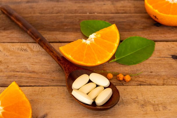 vitamine c pilules complément alimentaire pour les soins de santé avec arrangement de coupe orange plat style laïc sur fond blanc - Photo, image