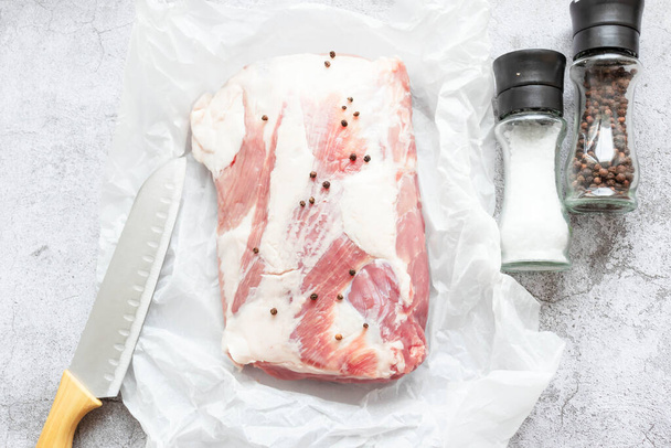 Stück rohes Schweinefleisch auf grauem Hintergrund. Frisches Fleisch ist fertig zum Kochen. Blick von oben - Foto, Bild