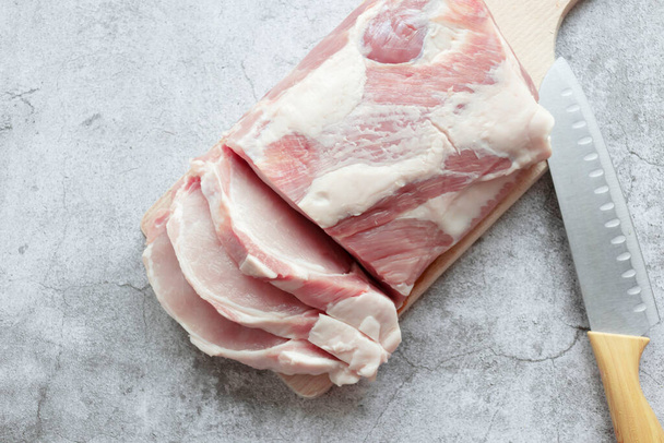 灰色の背景に生の豚肉のピース.新鮮な肉を調理する準備ができています.上からの眺め - 写真・画像