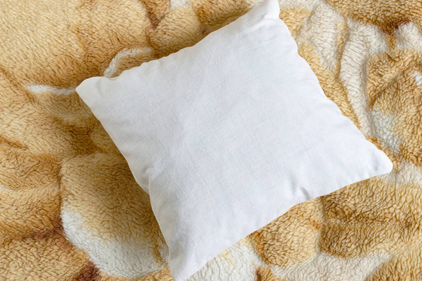 White pillow mockup on background of fur blanket. Clean white pillow, bedding design mockup. Blank surface, top view, copy space - Photo, Image