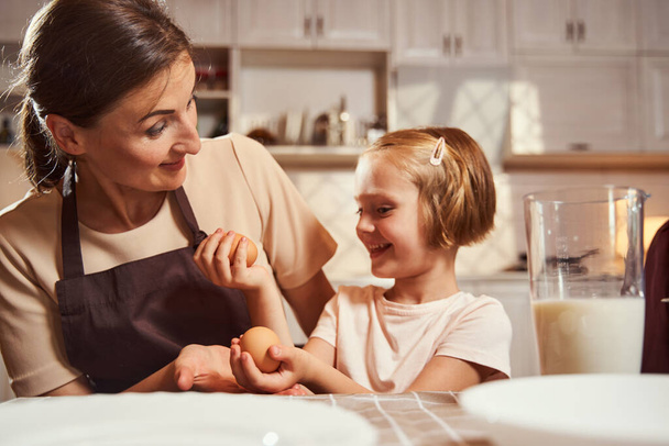 Girl choosing between two eggs with her mother - Foto, immagini