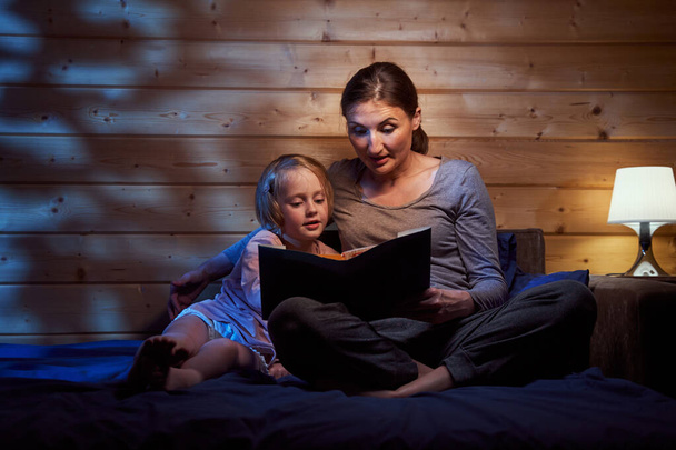 Mother reading bedtime stories to her child - Fotó, kép