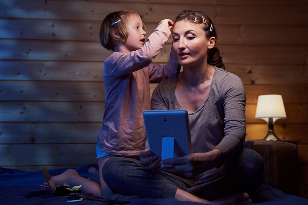 Girl pinning hair of her mother while listening to stories - Φωτογραφία, εικόνα