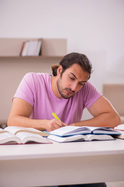 Joven estudiante masculino preparándose para los exámenes en casa - Foto, Imagen