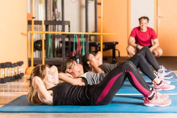 Widok z boku sportowiec kobiety robi ćwiczenia brzucha w siłowni - Zdjęcie, obraz