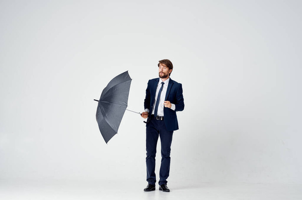 мужчина в костюме с зонтиком в руках защищает от дождя элегантный стиль во всю длину - Фото, изображение