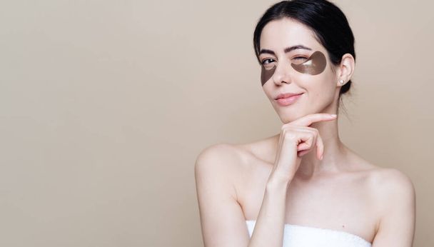 Junge schöne Frau mit sauberer, frischer Gesichtshaut, verwendet Augenklappen - Foto, Bild