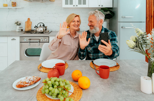 Paar begrüßt Freunde mit Videoanruf beim Frühstück - Foto, Bild
