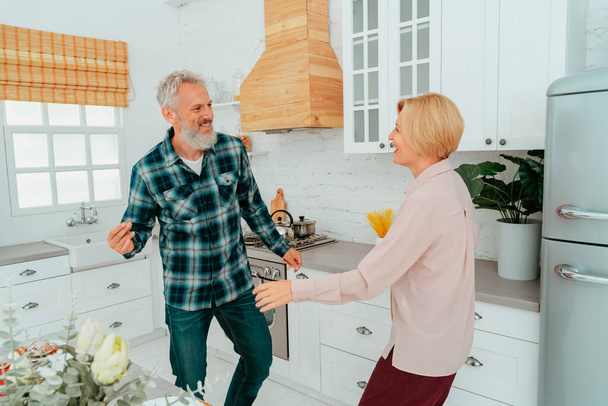 husband and wife dance at home during breakfast - Photo, Image