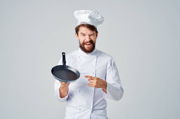 Chef met een koekenpan in de hand op geïsoleerde achtergrond. Hoge kwaliteit foto - Foto, afbeelding