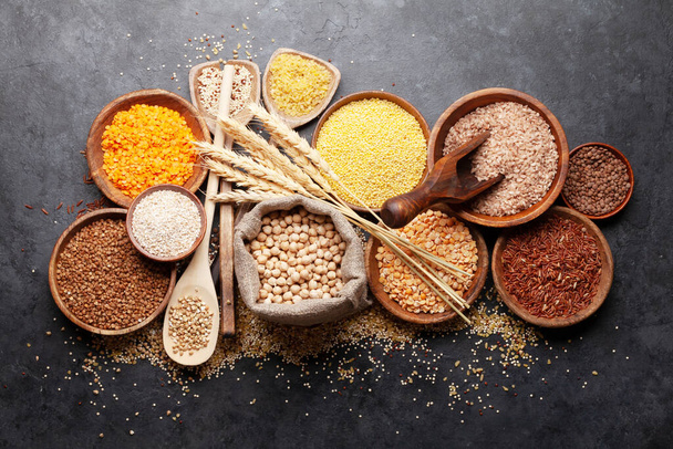 Cereales sin gluten. Arroz, trigo sarraceno, grañones de maíz, quinua y mijo en tazones de madera. Vista superior plano laico - Foto, imagen