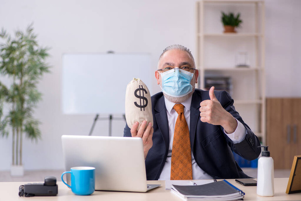 Old male employee during pandemic in remuneration concept - Foto, Bild