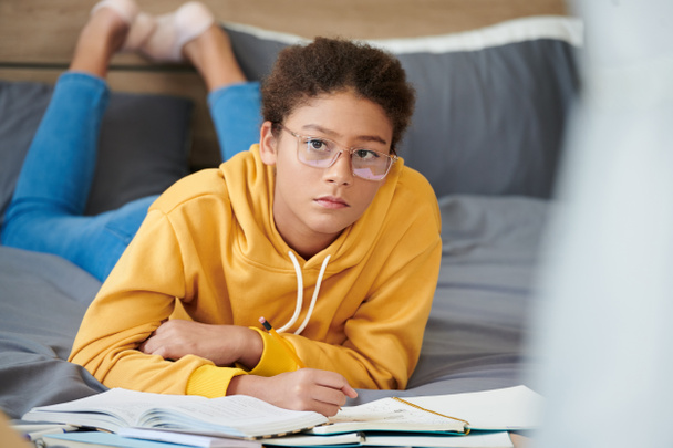 Девочка-подросток пишет эссе в учебнике - Фото, изображение