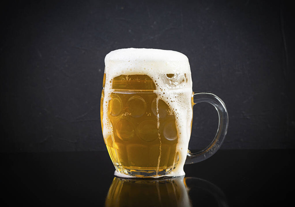 Mug of light beer on dark background. Craft unfiltered beer - Foto, Bild