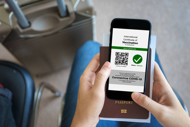 Ανοσοποιητικό διαβατήριο, Τουριστικές χρήσεις της εφαρμογής στο smartphone για να δείξει μια διεθνή πιστοποίηση του εμβολιασμού στο αεροδρόμιο με Ασυλίας διαβατήριο και κάρτα καταγραφής εμβολιασμών για covid-19 - Φωτογραφία, εικόνα