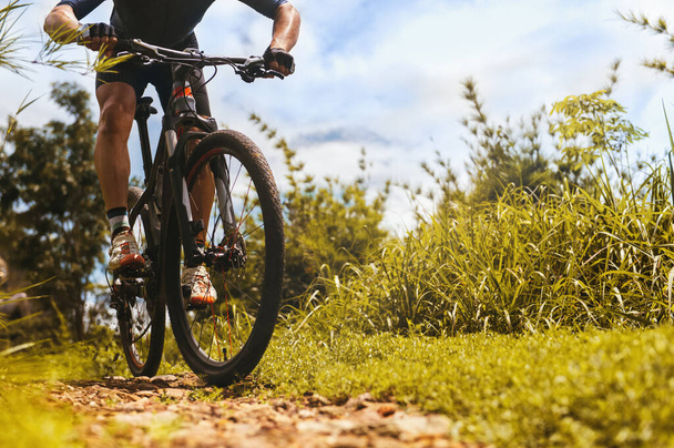 Maastopyöräily matala kulma näkymä, Pyöräilijä ratsastaa koulutusta MTB radalla metsässä maastopyörä, Ulkouima urheilu toimintaa hauskaa ja nauttia ratsastus. Urheilijan perustekniikka. Valinta keskittyä pyöräily jalka - Valokuva, kuva