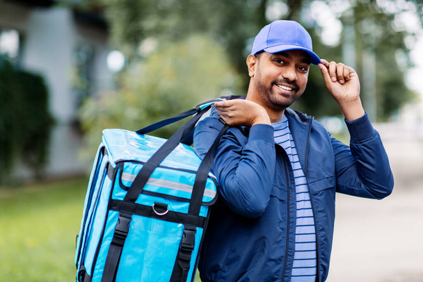 happy smiling indian delivery man with bag in city - Foto, Bild