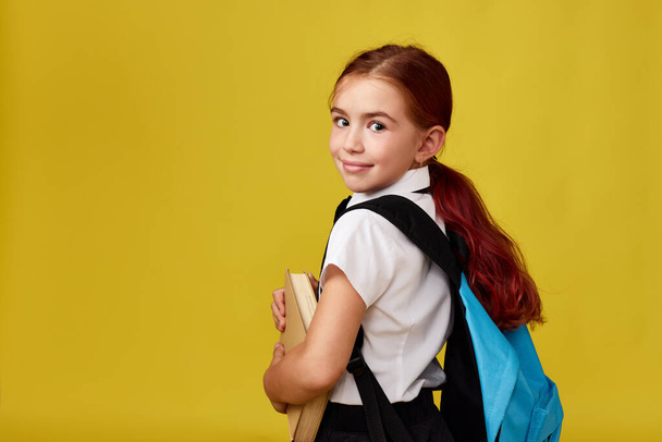 cute happy schoolgirl with backpack and book - Photo, Image