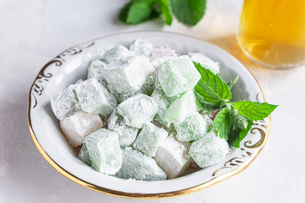 Turkish delight lokum on a plate with a glass of tea - Foto, Imagem