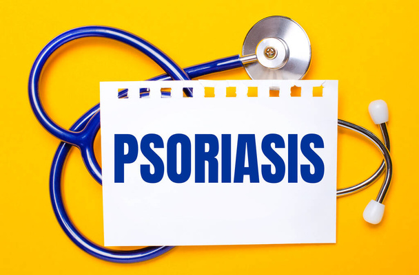 On a bright yellow background, a blue stethoscope and a sheet of paper with the text PSORIASIS. Medical concept - Φωτογραφία, εικόνα