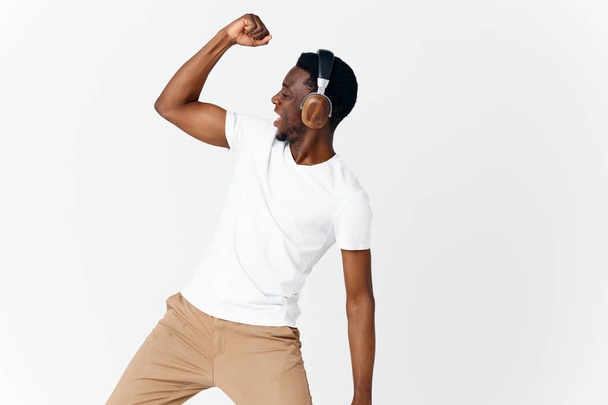 muž afrického vzhledu ve sluchátkách gestikulace s ruční hudbou zábavy - Fotografie, Obrázek